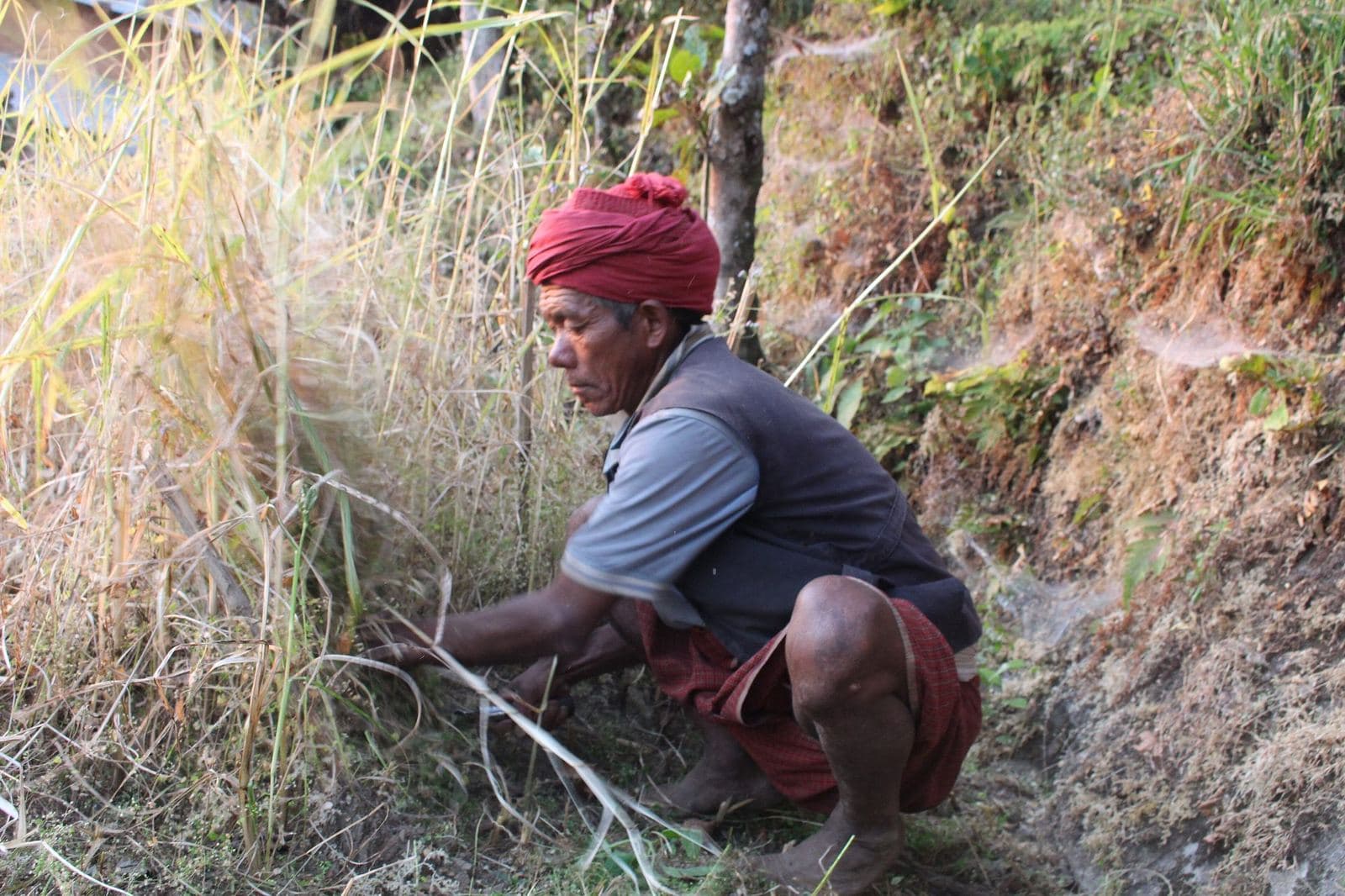 A farmer working a steep hillside plot in rural Nepal